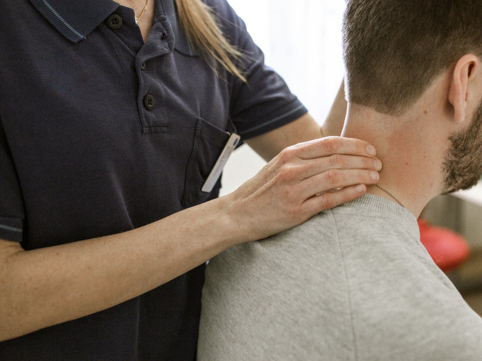 Fysioterapeut undersöker patients nacke