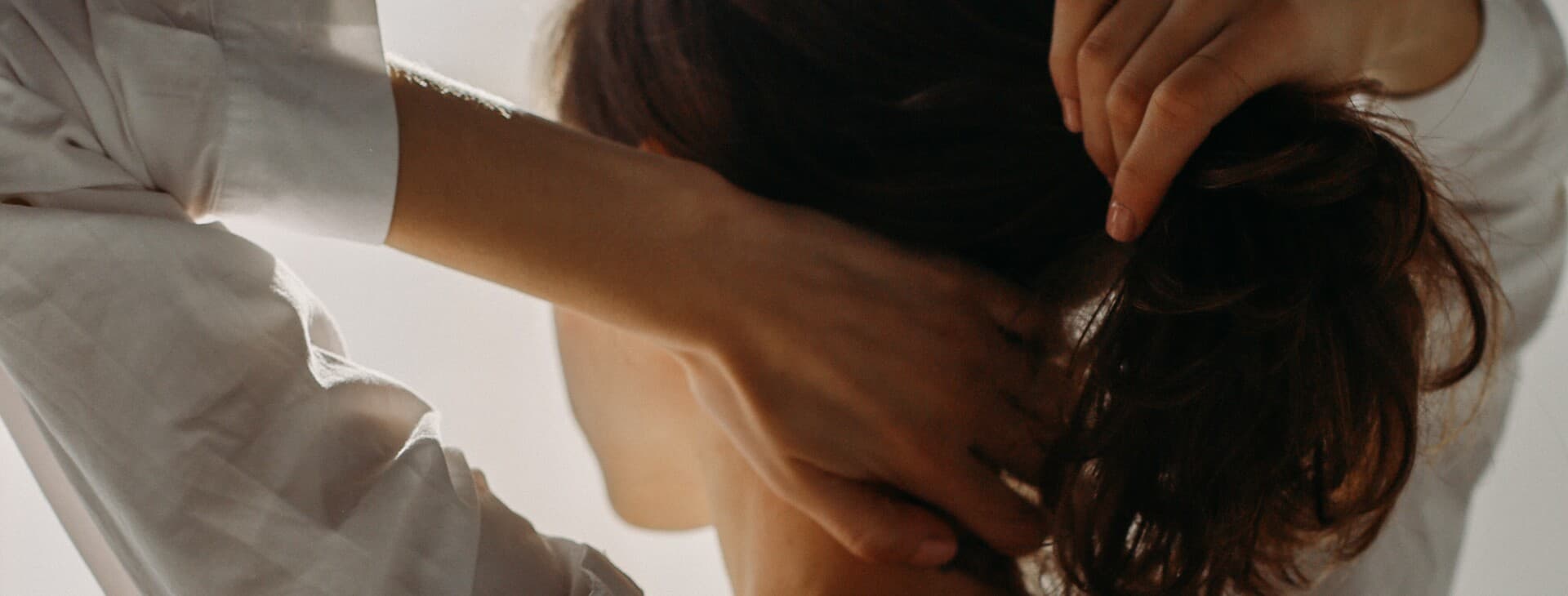 Ung tjej i skjorta sätter upp sitt hår Ung tjej i skjorta sätter upp sitt hår