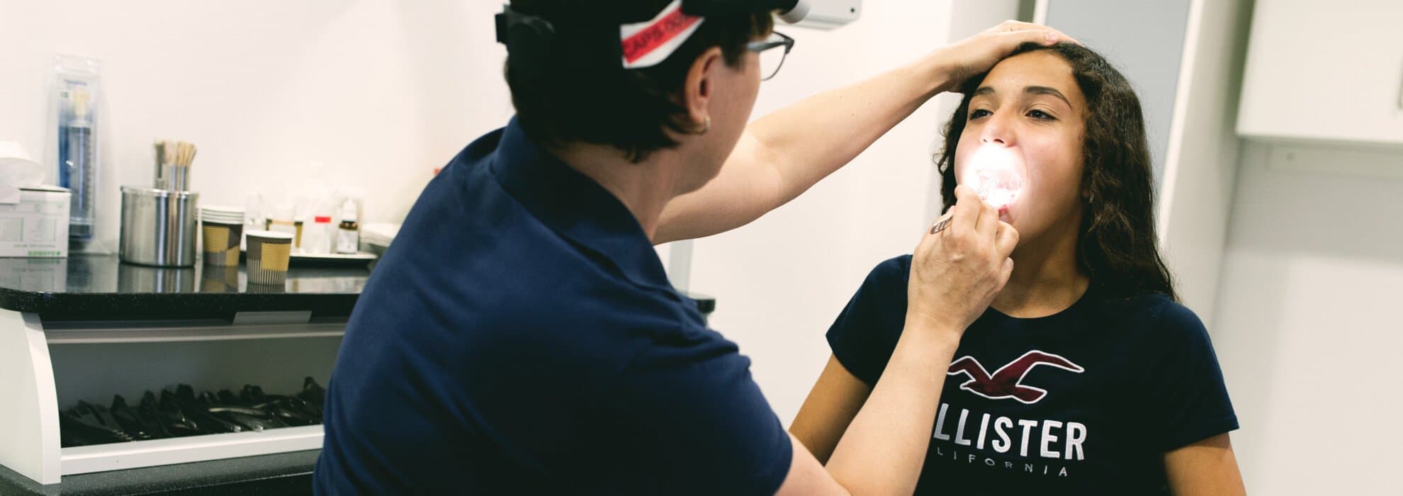 Läkare undersöker barns hals