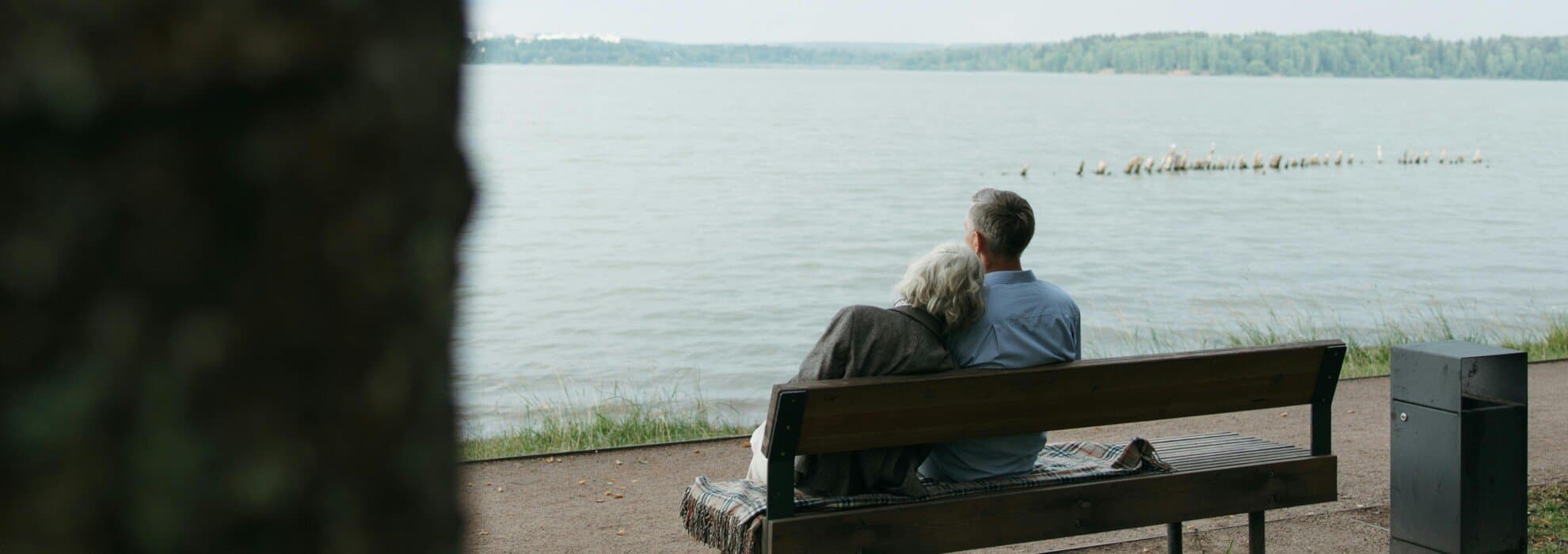 Par sitter på bänk vid havet