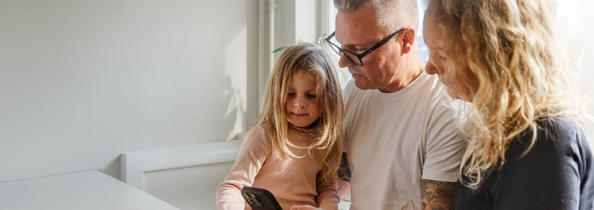 Familj med barn tittar i telefon Familj med barn tittar i telefon