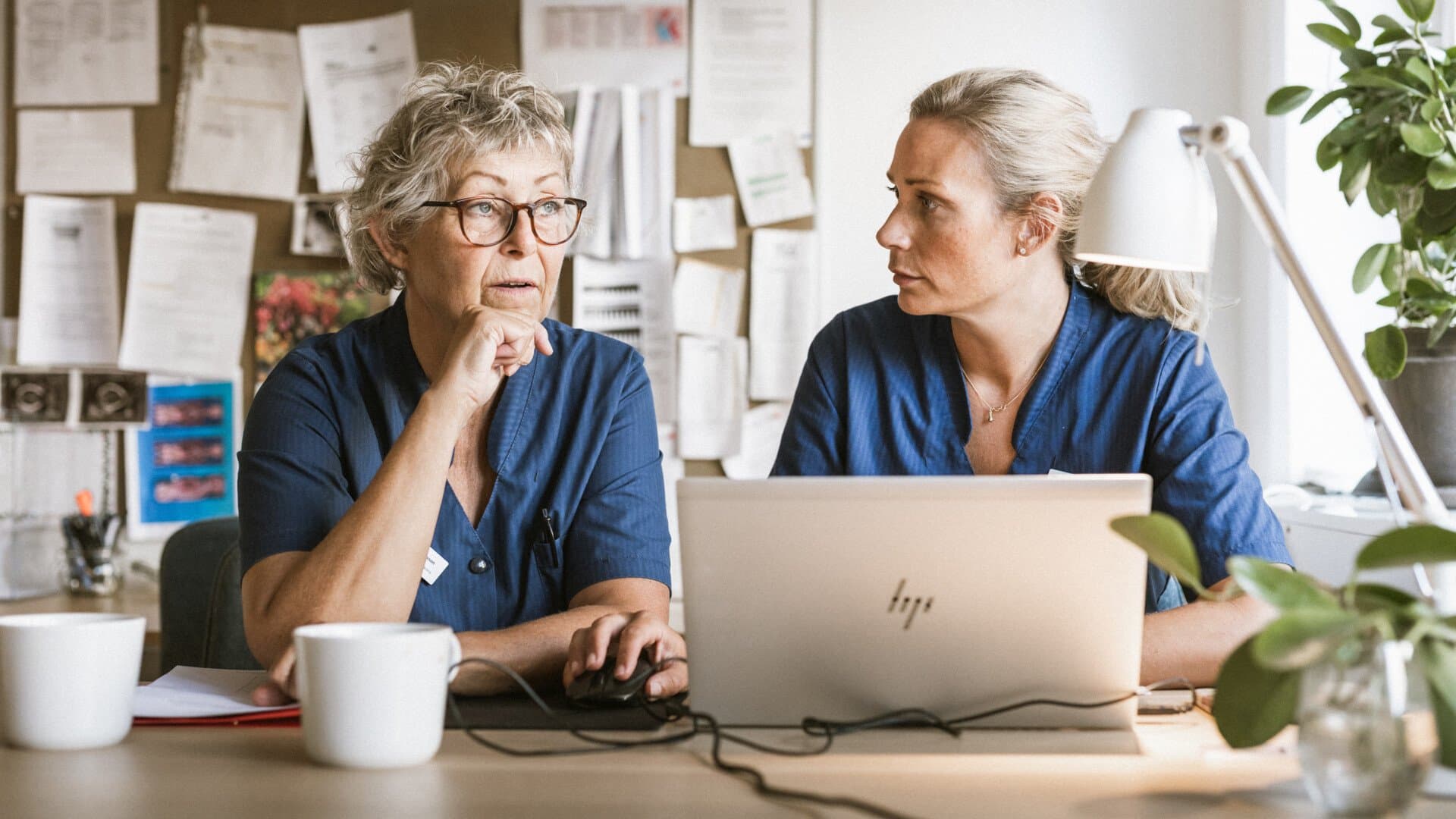 Två kvinnor sitter vid en laptop Två kvinnor sitter vid en laptop