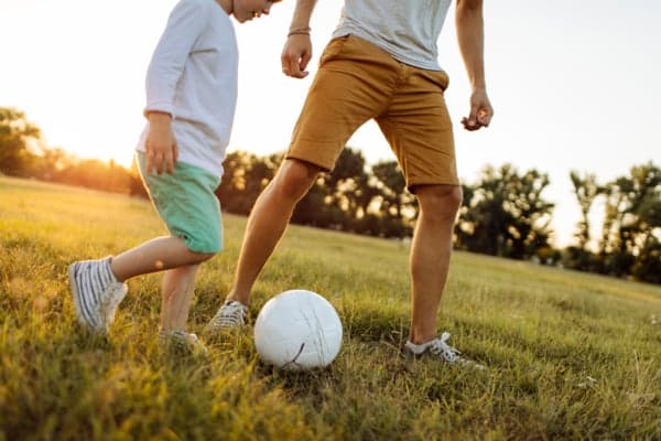 Barn och vuxen spelar fotboll. Barn och vuxen spelar fotboll.
