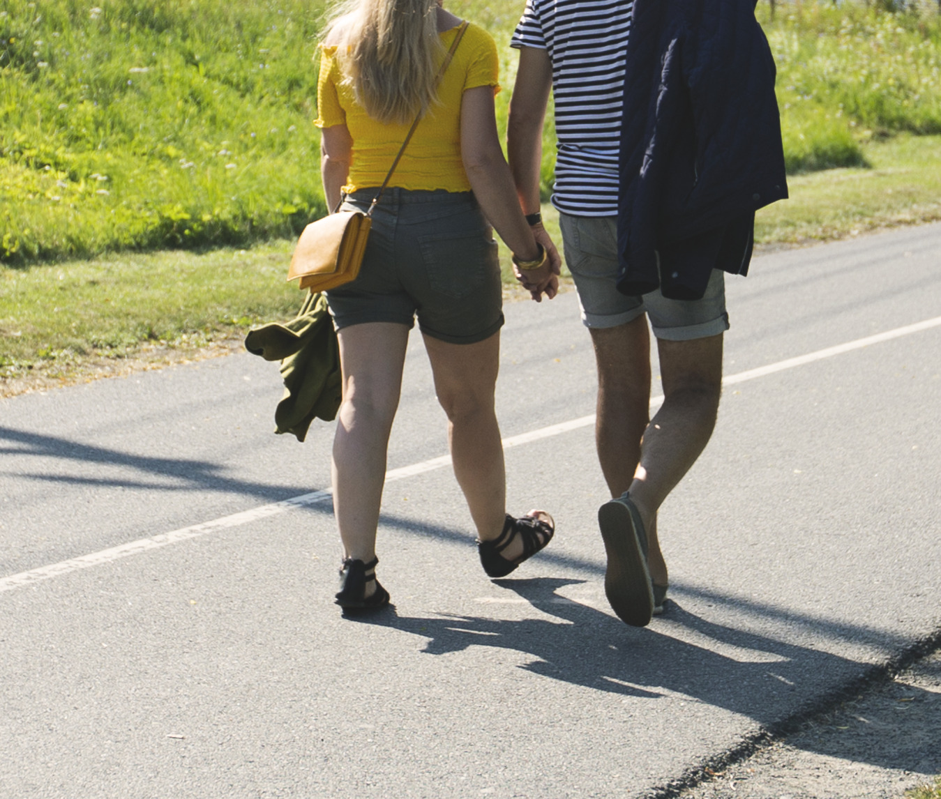 Promenerande par håller varandra i handen