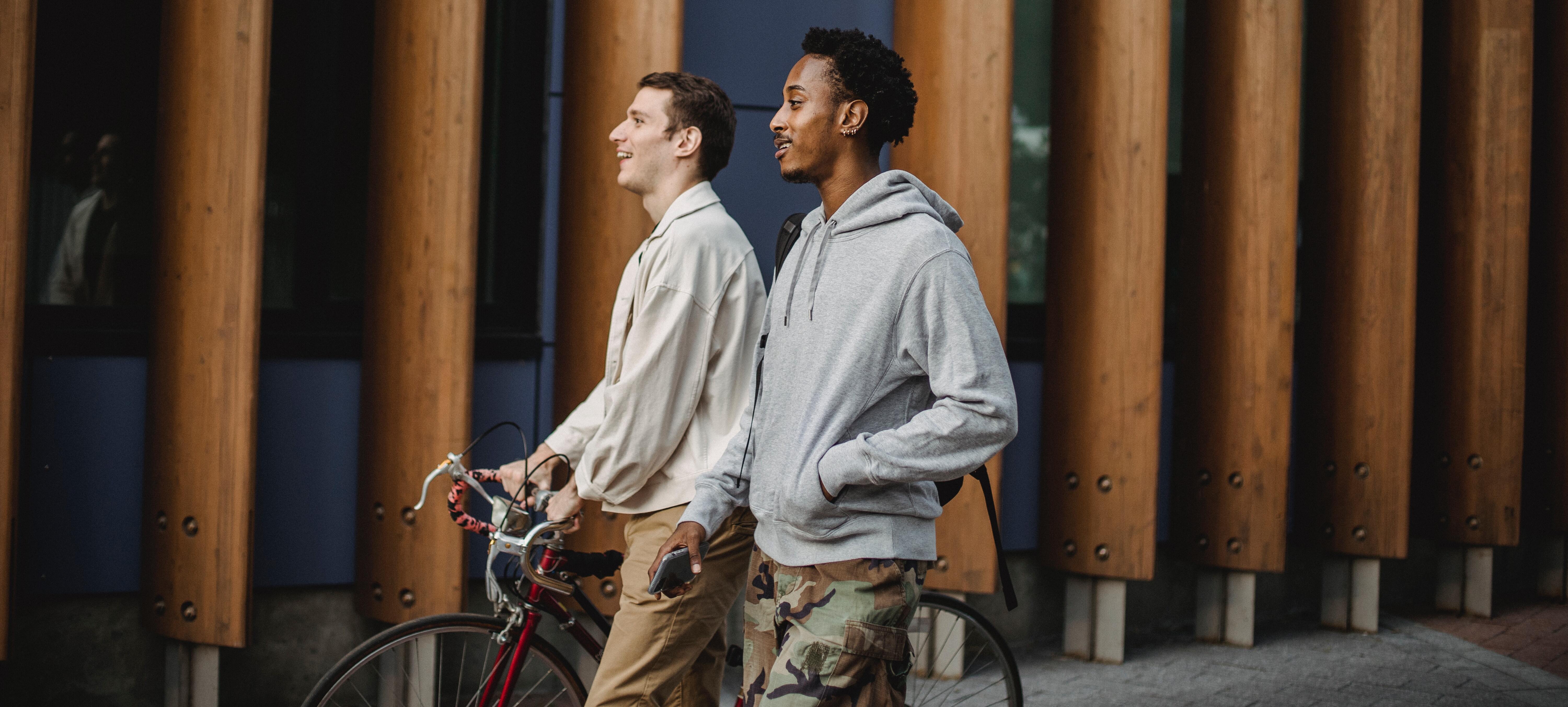 Unga män med cykel i storstadsmiljö