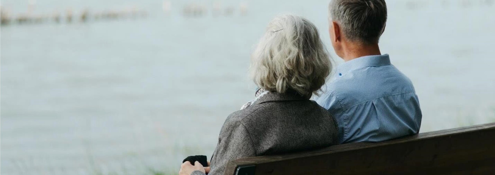 äldre par som sitter på en bänk