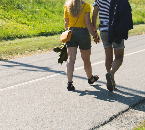 Promenerande par håller varandra i handen