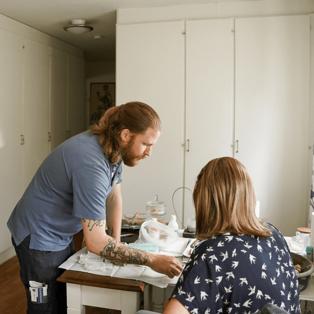 Sjuksköterska som pratar med patient, hemma hos patienten