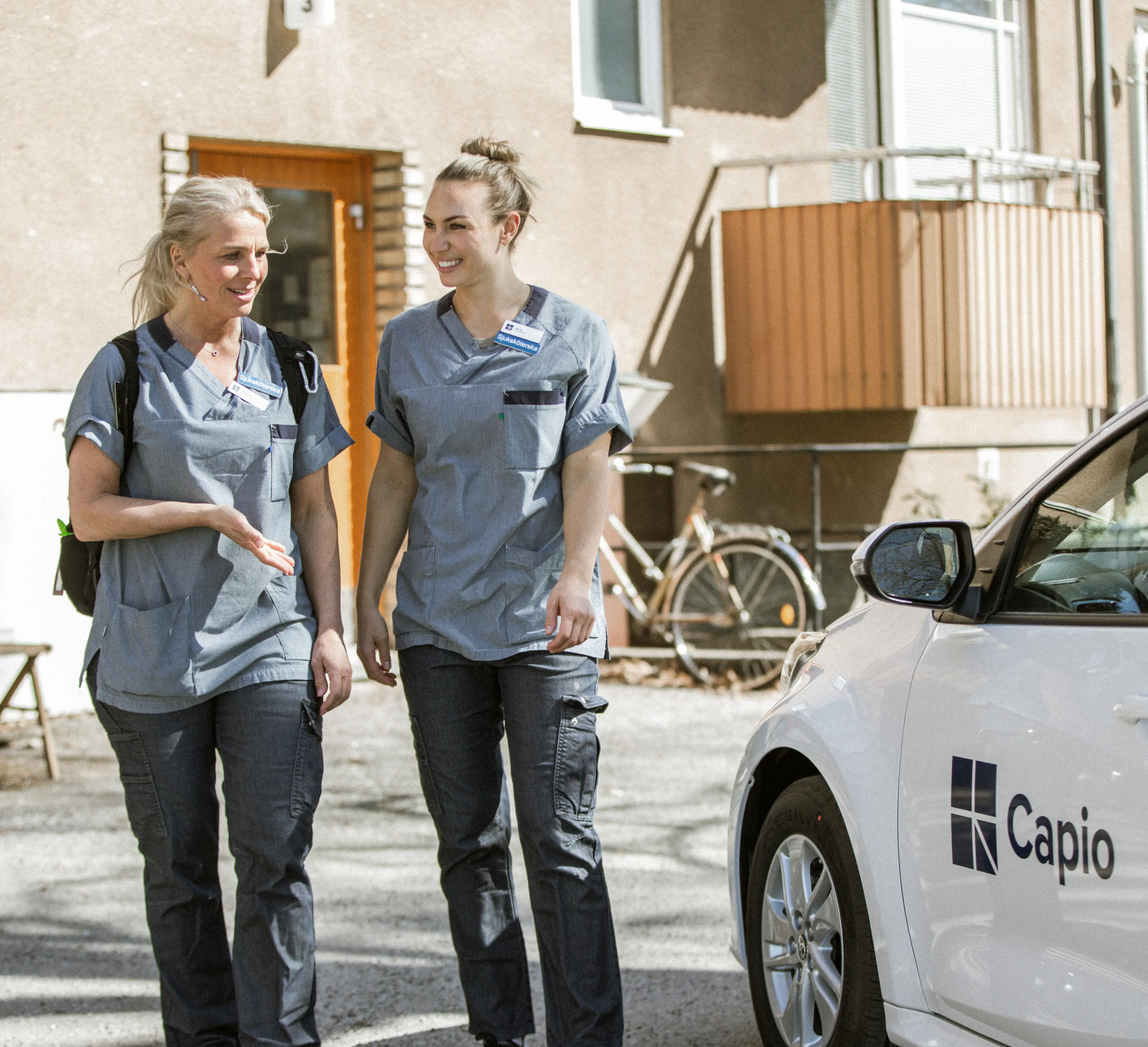Två kvinnor som pratar utanför en bil